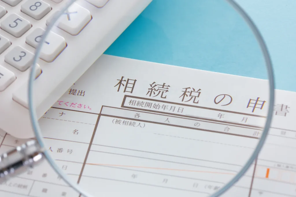 相続税の申告書を虫眼鏡で確認するイメージ